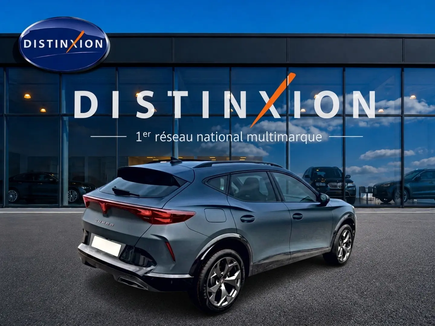 Vue 3/4 arrière droite d'un CUPRA Formentor bleu fjord avec jantes 18 pouces devant un showroom Distinxion.
