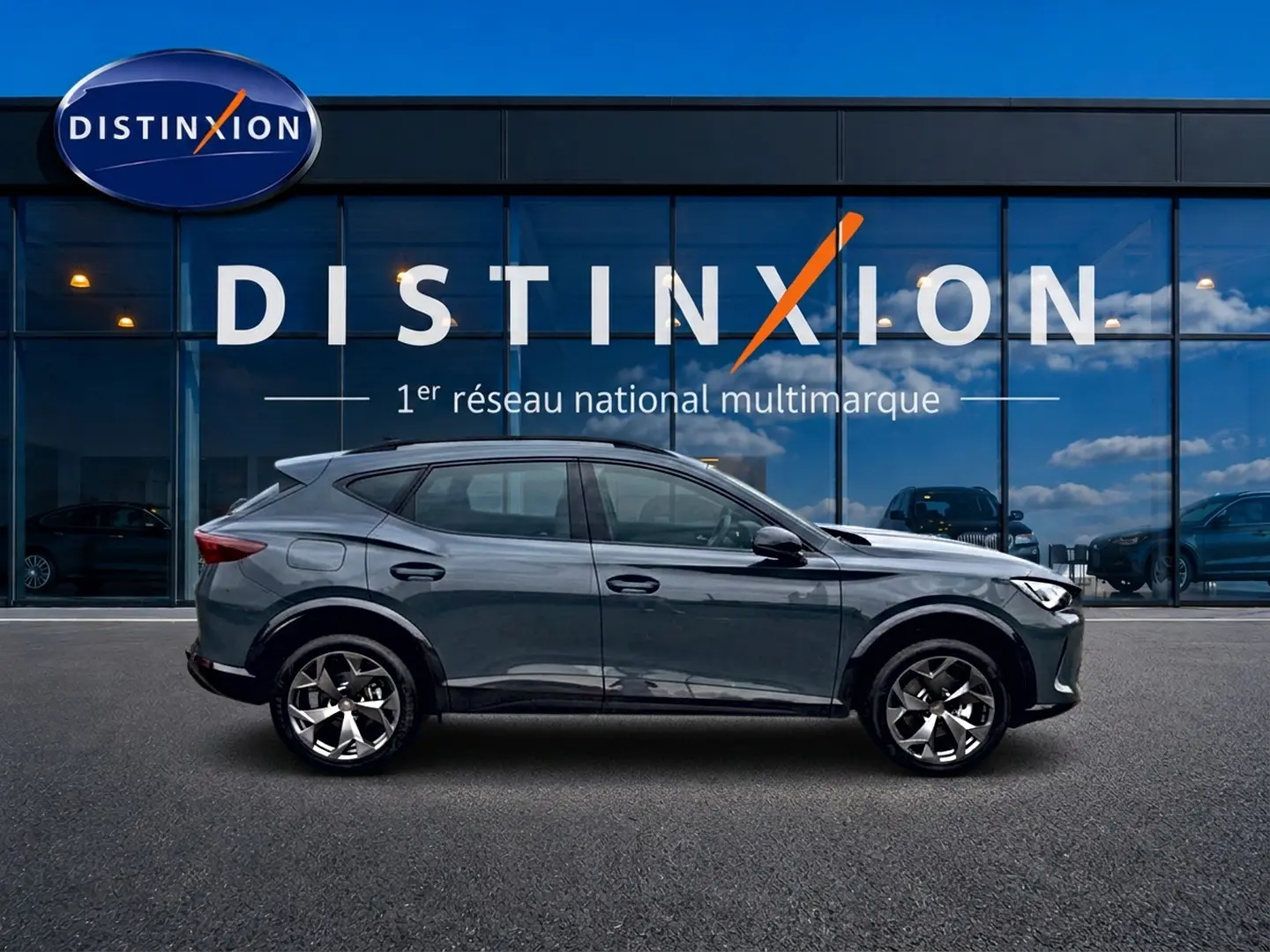 Vue latérale droite d'un CUPRA Formentor bleu fjord 2026 avec jantes 18 pouces devant une vitrine Distinxion.