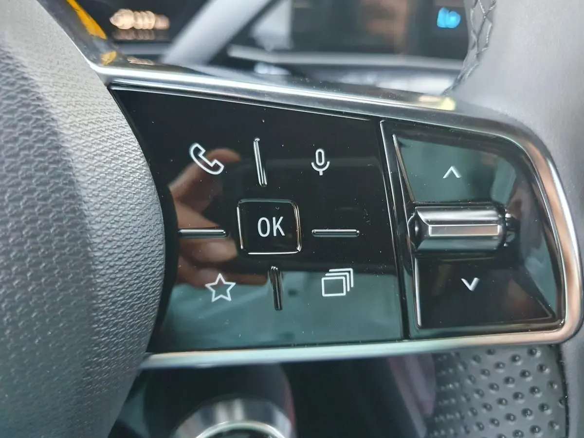 Gros plan sur les commandes multifonctions noires à droite du volant dans l’habitacle de la Renault R5 E-TECH jaune Pop.