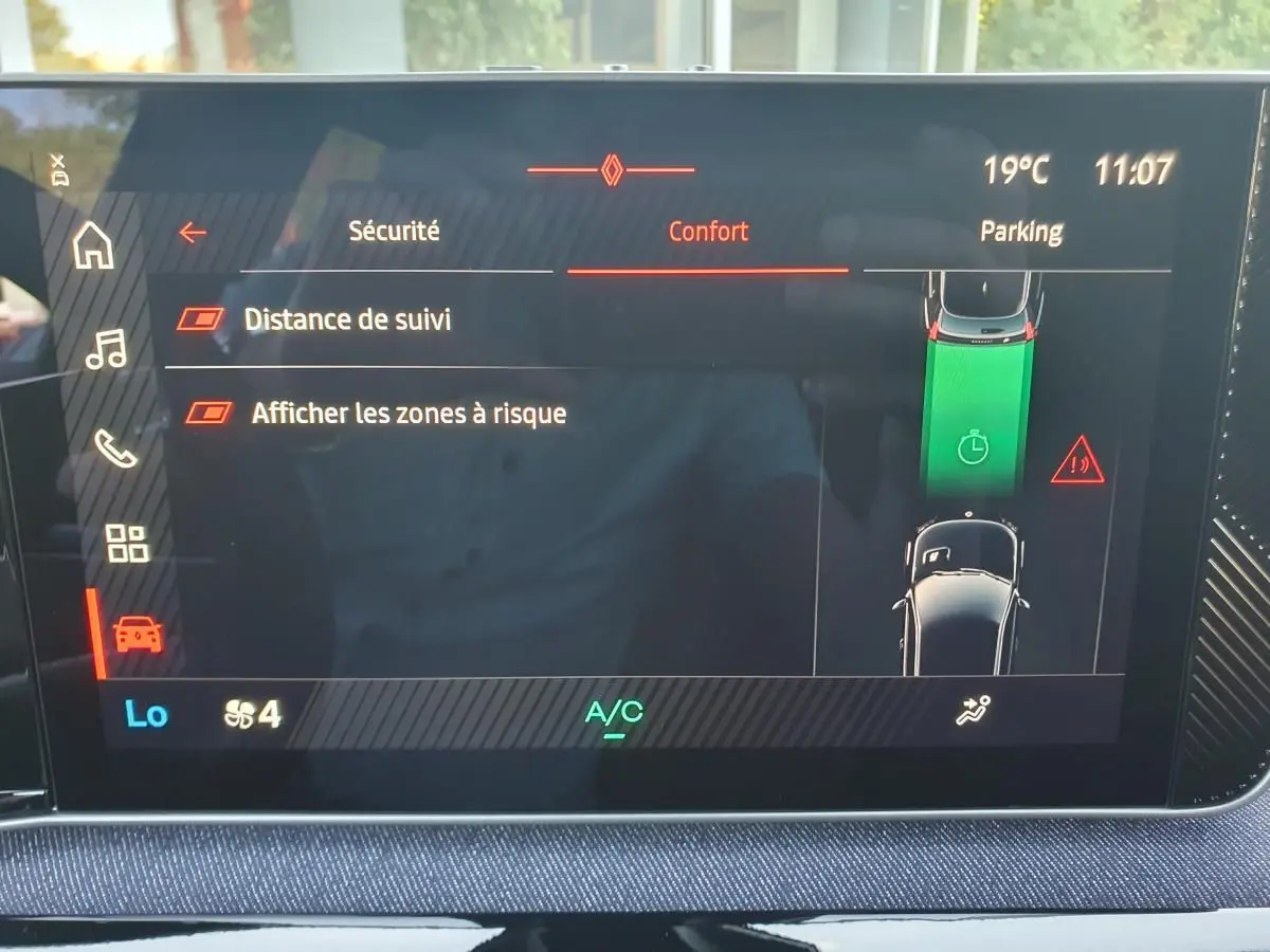 Écran tactile central de la Renault R5 E-TECH jaune, affichant les réglages de sécurité et assistance au stationnement.