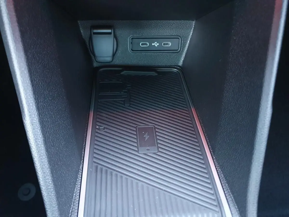Gros plan sur la zone de recharge sans fil et les ports USB-C dans le compartiment central de la Renault R5 E-TECH jaune pop.
