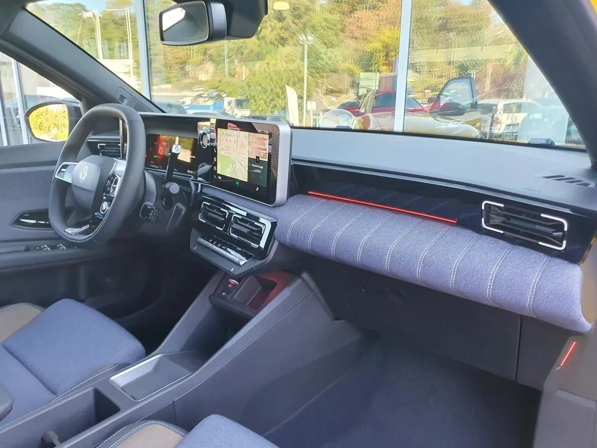 Intérieur Renault R5 E-Tech 2026 côté conducteur, tableau de bord moderne avec écran tactile et tissu bleu clair.