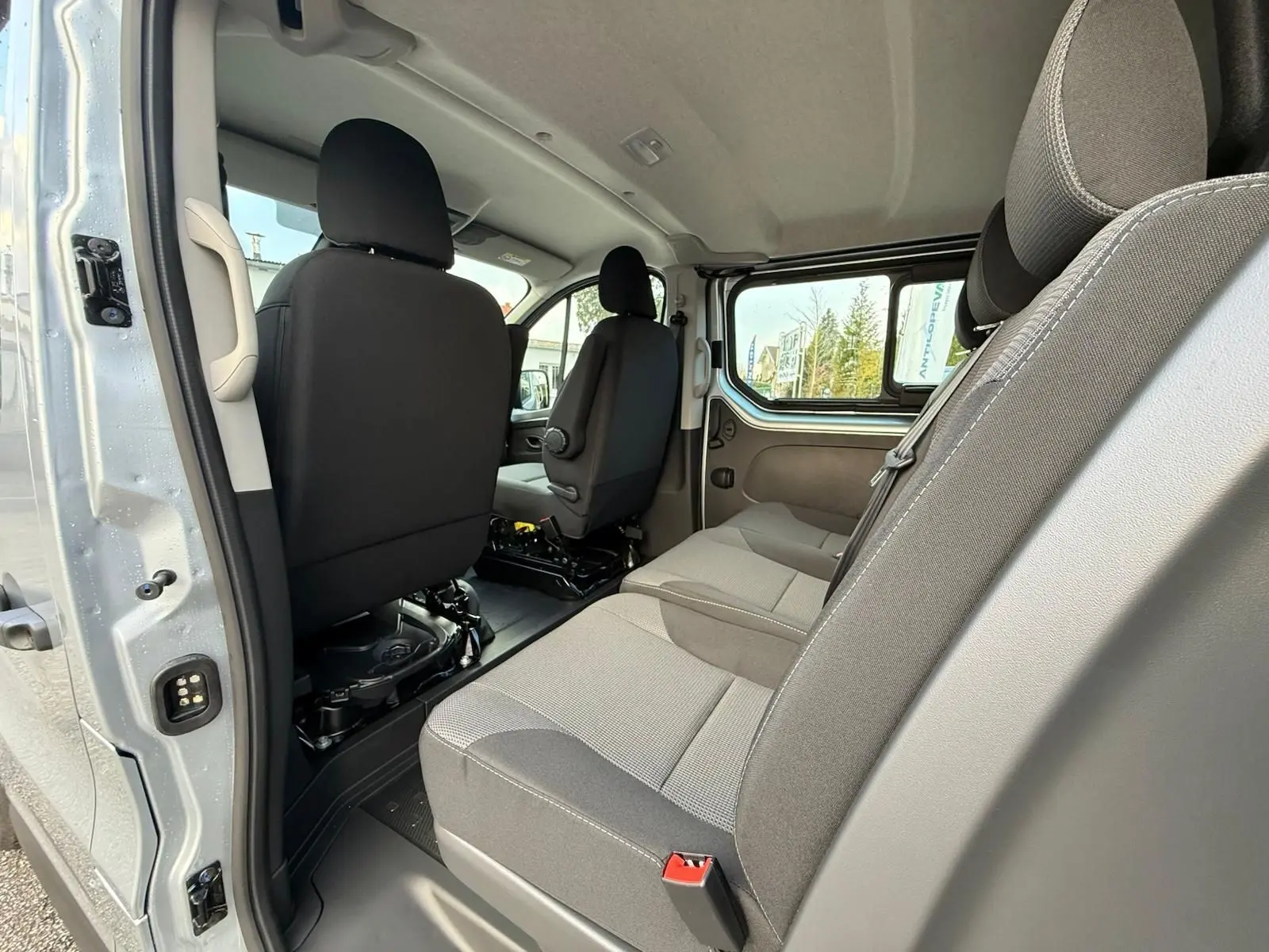 Gros plan sur l'avant droit gris Highland du Renault Trafic cabine approfondie 2025 avec calandre noire et phares LED.