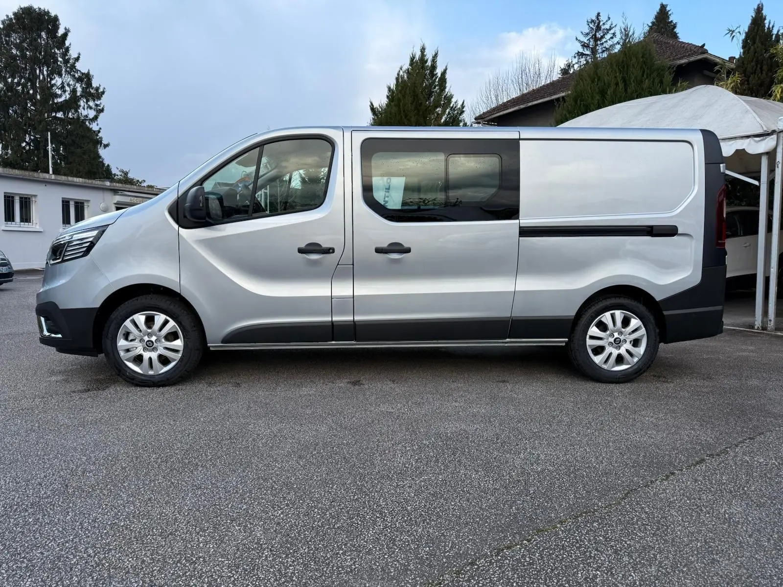 Vue frontale d'un Renault Trafic cabine approfondie gris Highland 2025 avec calandre noire et logo Renault bien visible.