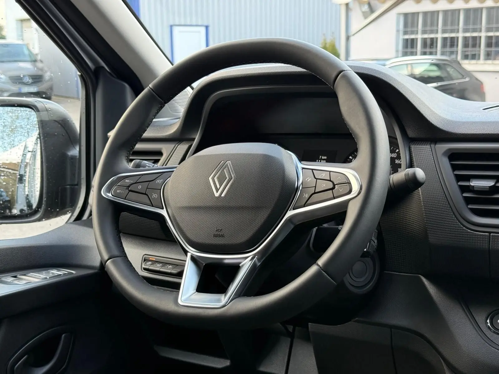 Renault Trafic cabine approfondie gris Highland en 3/4 avant droit, avec calandre noire et jantes argentées.