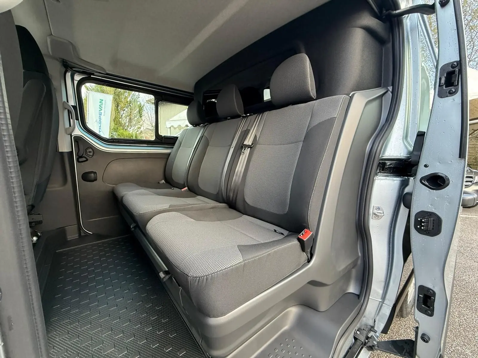 Intérieur Renault Trafic cabine approfondie 2025, vue frontale du poste de conduite avec volant, tableau de bord et levier de vitesses.
