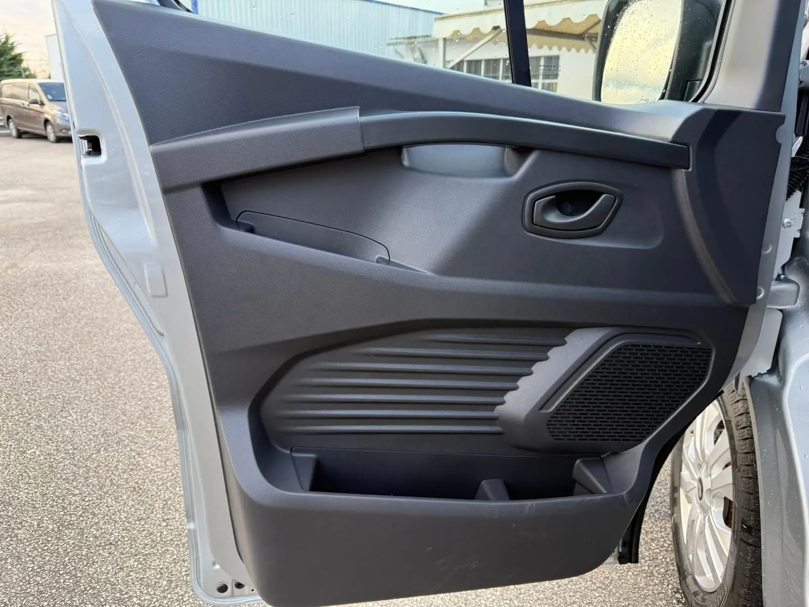 Écran tactile central du tableau de bord du Renault Trafic cabine approfondie 2025 avec commandes climatisation et radio visibles.