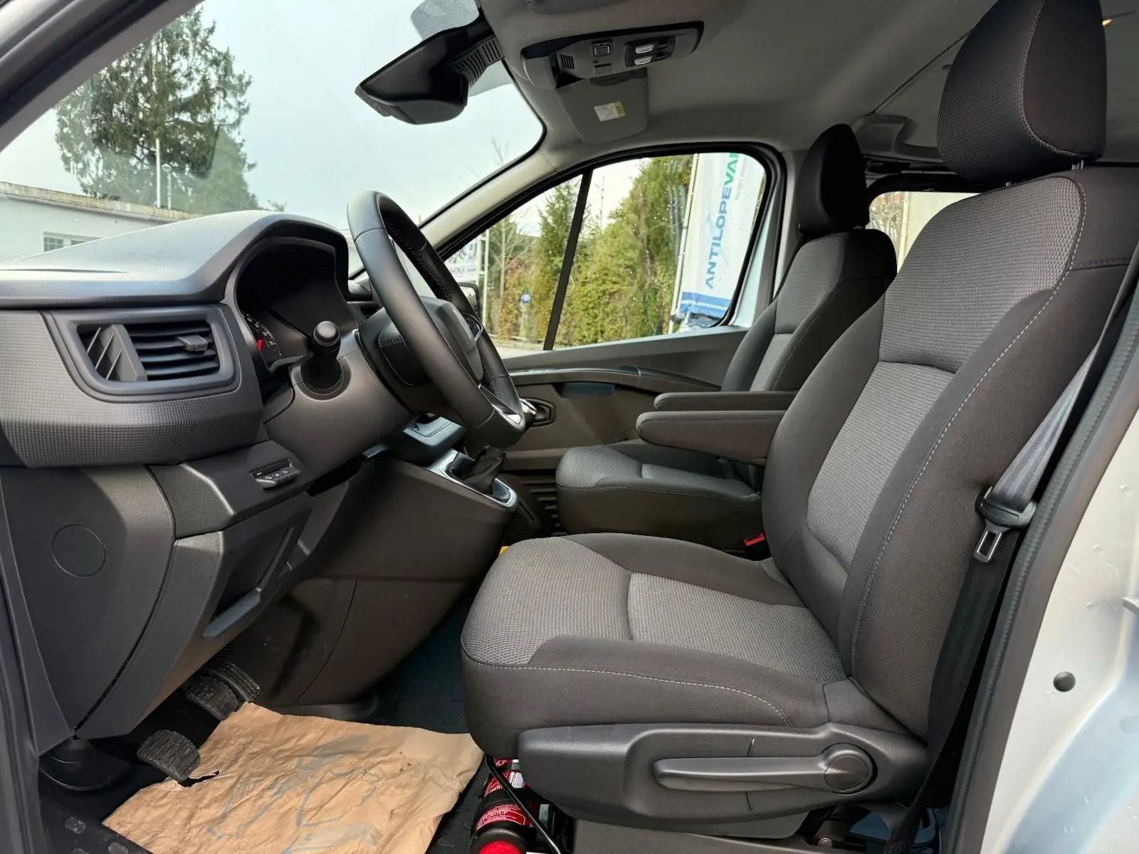 Renault Trafic cabine approfondie gris Highland vu de profil côté gauche, avec fenêtres teintées et jantes alliage.