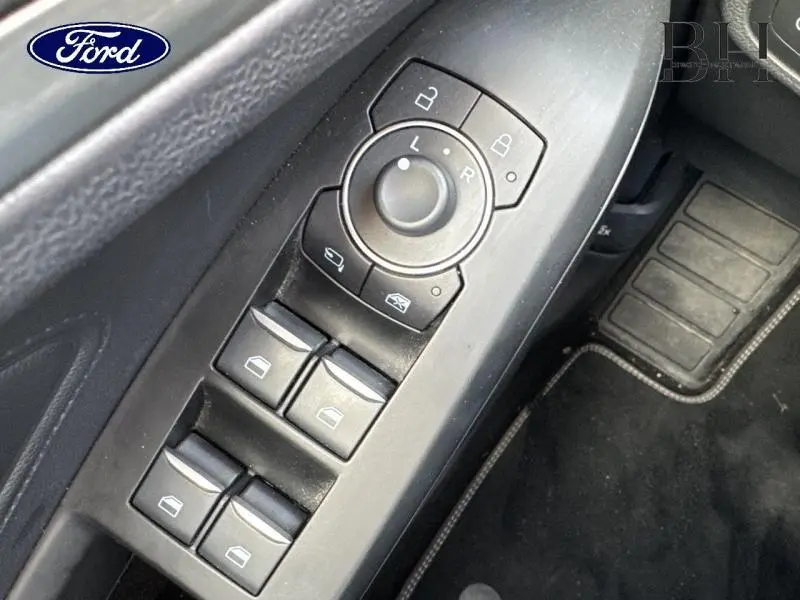 Gros plan sur les commandes de vitres et rétroviseurs côté conducteur d'une Ford Focus SW gris lunaire 2023