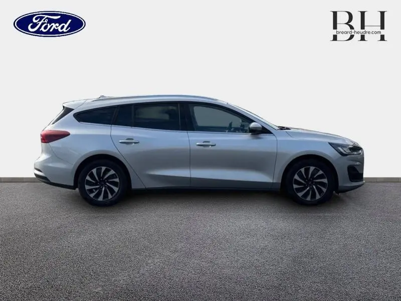 Profil droit d'une Ford Focus SW 2023 gris lunaire métallisé avec vitres arrière surteintées et jantes stylisées.