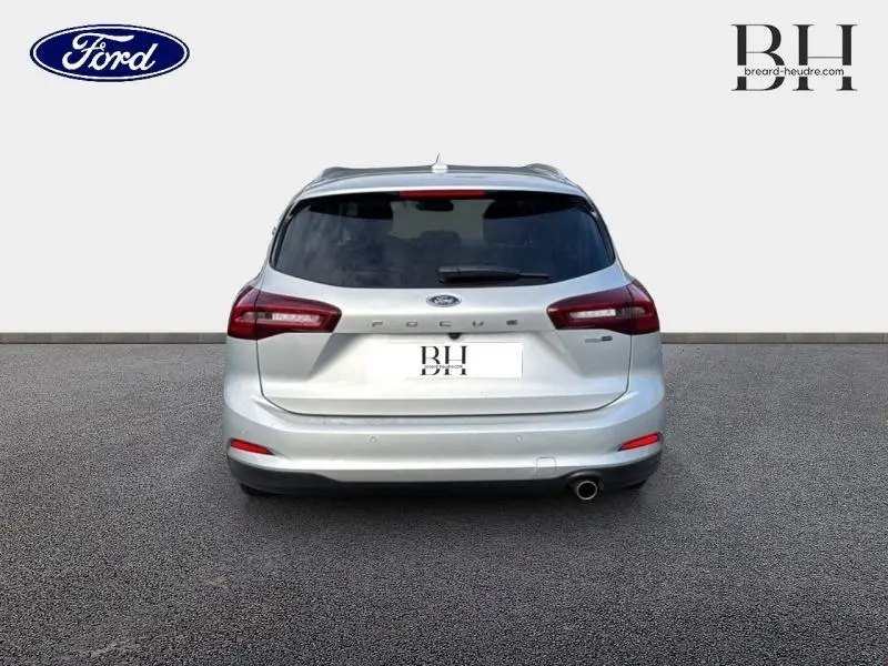 Vue arrière d'une Ford Focus SW 2023 gris lunaire métallisé avec feux arrière LED et sortie d'échappement chromée visible.