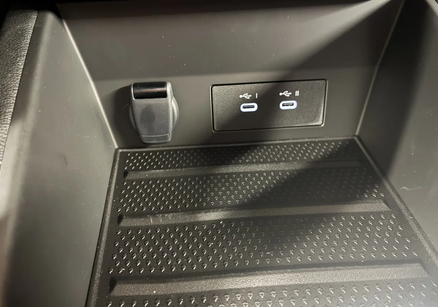 Prise USB double et prise 12V dans le compartiment de rangement noir du Renault Captur E-Tech 2025.