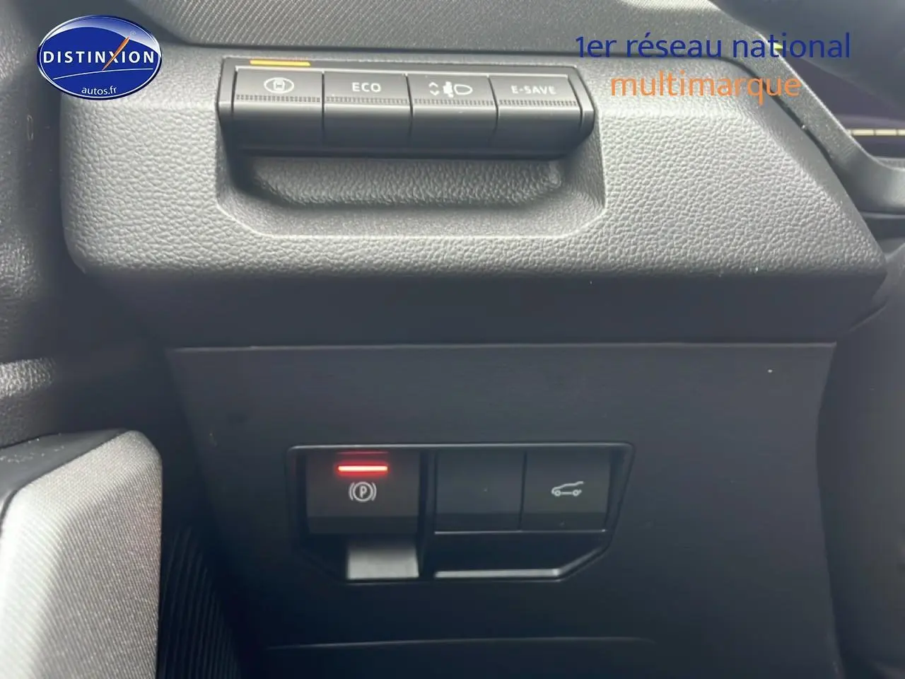 Gros plan sur les commandes de frein à main électronique et ouverture de coffre dans un Dacia Bigster 1.8 hybrid noir 2025.