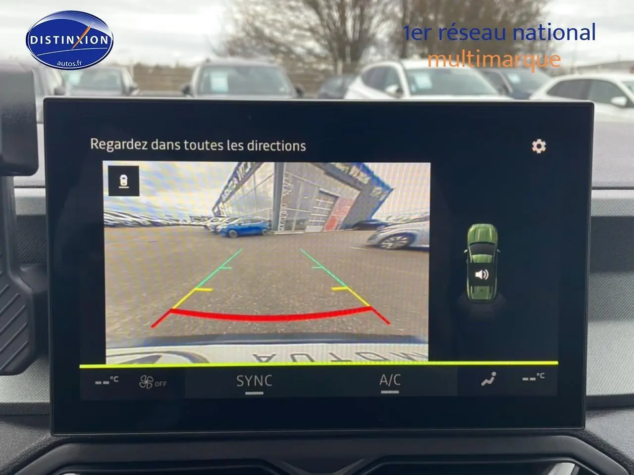 Écran central montrant la caméra de recul du Dacia Bigster noir avec lignes d’aide au stationnement en extérieur.