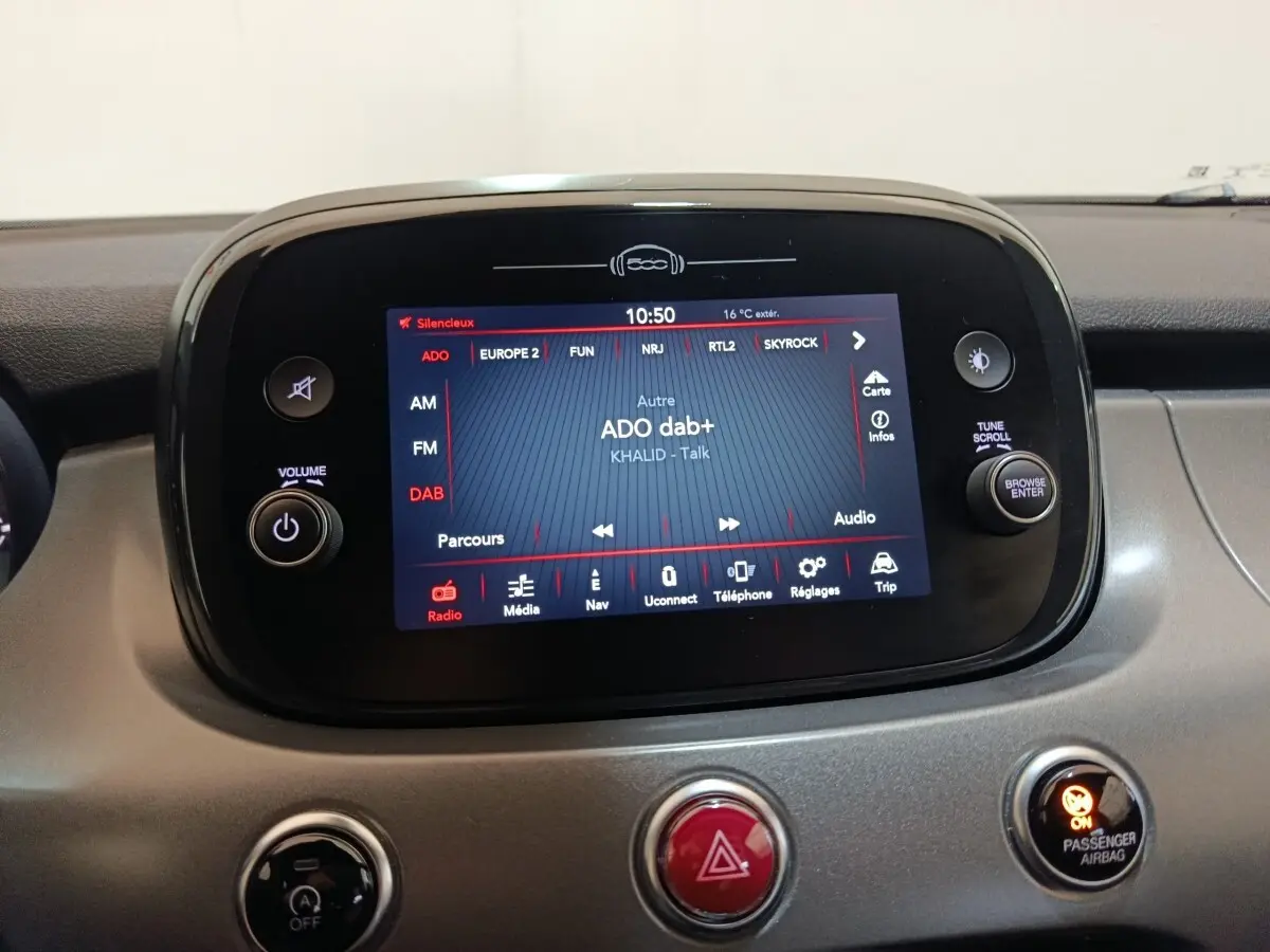 Écran tactile central allumé du tableau de bord de la Fiat 500X noir, affichant la radio DAB+ et les commandes multimédia.