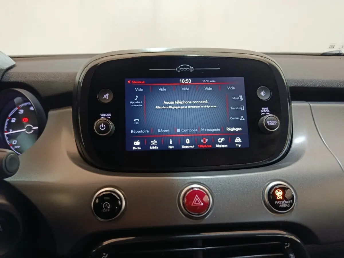 Vue rapprochée du tableau de bord gris du Fiat 500X 2021 avec écran tactile central allumé affichant le menu téléphone.