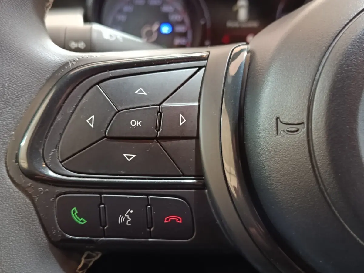 Gros plan sur les commandes multifonctions noires à gauche du volant de la FIAT 500X noir, version 2021.