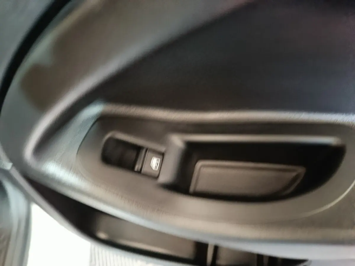 Gros plan sur la commande de lève-vitre côté gauche intérieur d'une FIAT 500X noire de 2021.