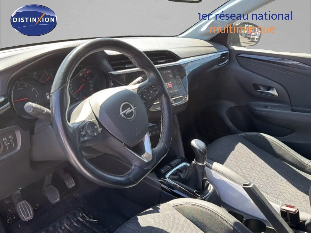 Vue intérieure côté conducteur de l’Opel Corsa 1.2 75 Elegance 2022 avec volant cuir noir et levier de vitesses manuel.