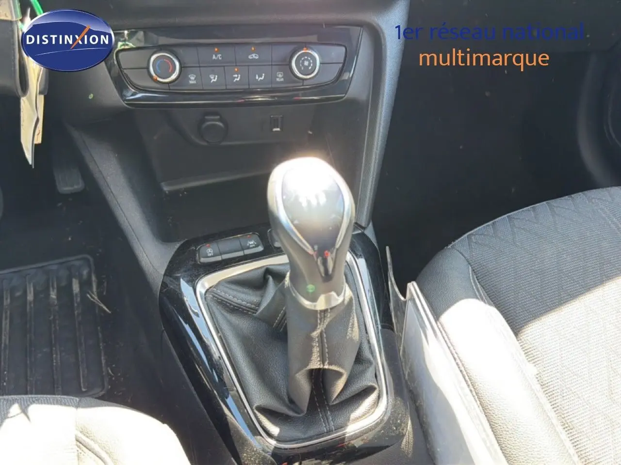 Gros plan sur la console centrale de l’Opel Corsa 1.2 75 Elegance 2022, levier de vitesse manuel et commandes climatisation.