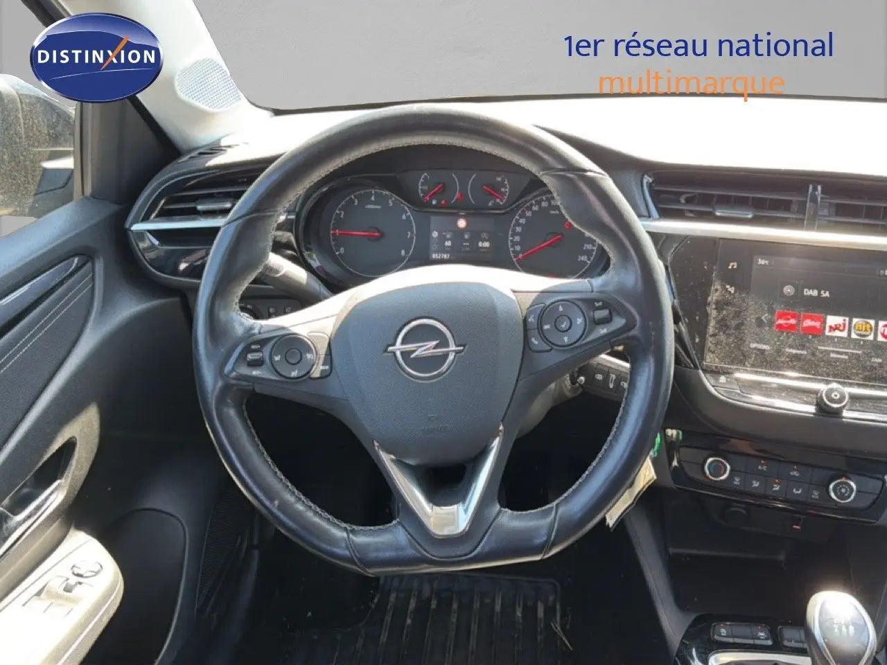 Vue intérieure centrée sur le volant cuir d'une Opel Corsa 1.2 75 Elegance avec tableau de bord et écran tactile.