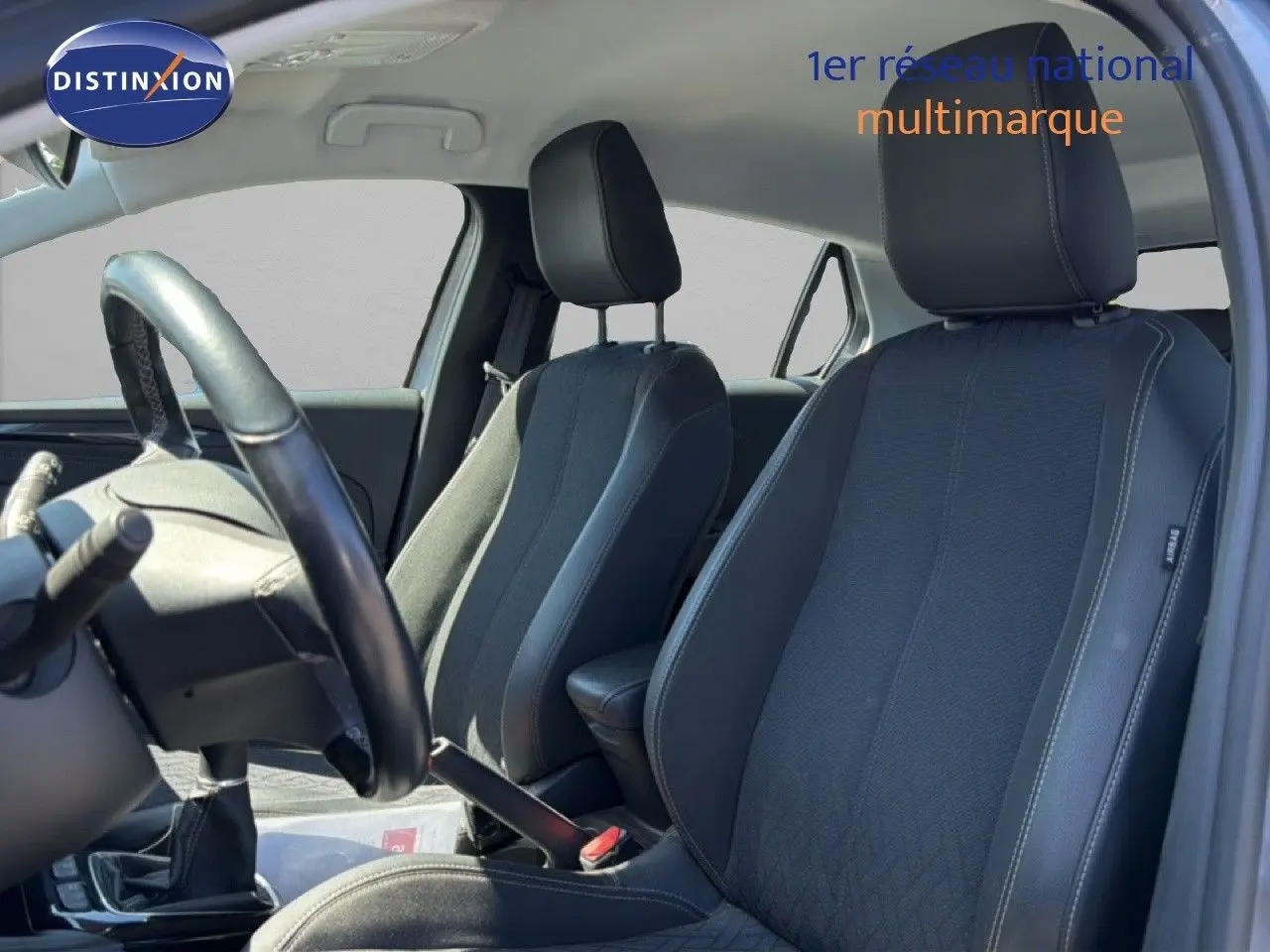 Vue intérieure côté conducteur de l’Opel Corsa 1.2 75 Elegance 2022 avec sièges tissu noir et volant cuir.