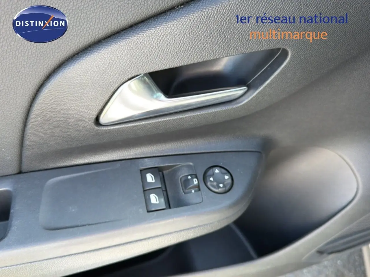 Gros plan sur la commande des vitres et rétroviseurs côté gauche de la porte intérieure d’une Opel Corsa gris quartz métal.