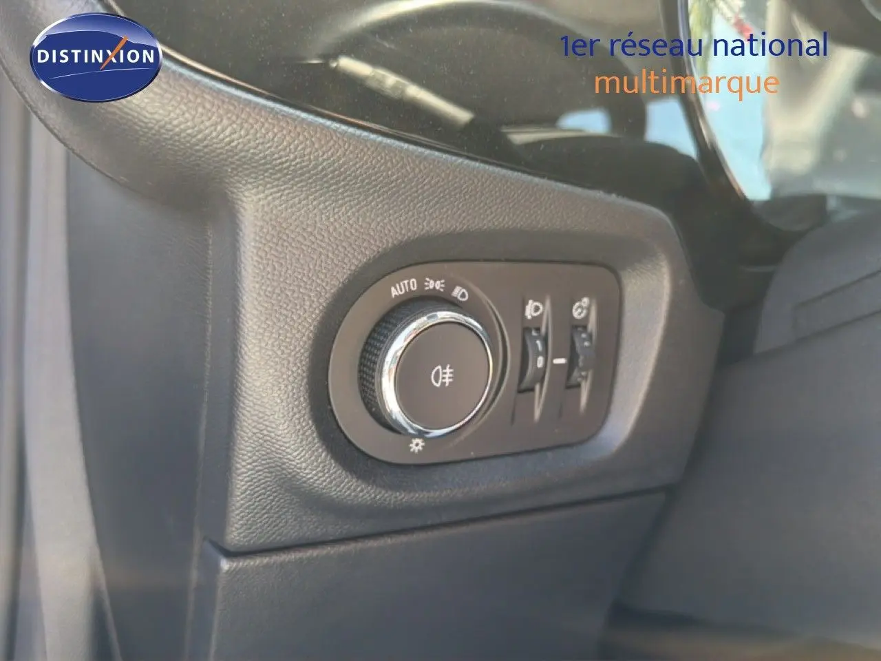 Gros plan sur le bouton de commande des phares à gauche du volant dans l’Opel Corsa gris quartz métal 2022.