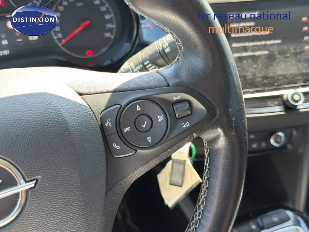 Vue rapprochée du volant en cuir noir de l’Opel Corsa gris quartz métal, avec commandes audio intégrées.
