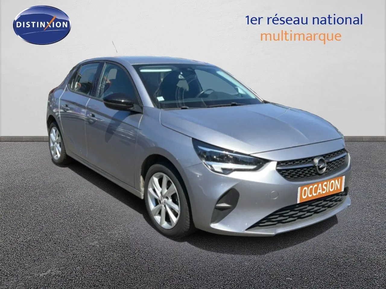 Opel Corsa 1.2 75 Elegance gris quartz métal vue 3/4 avant avec calandre noire et jantes argentées.