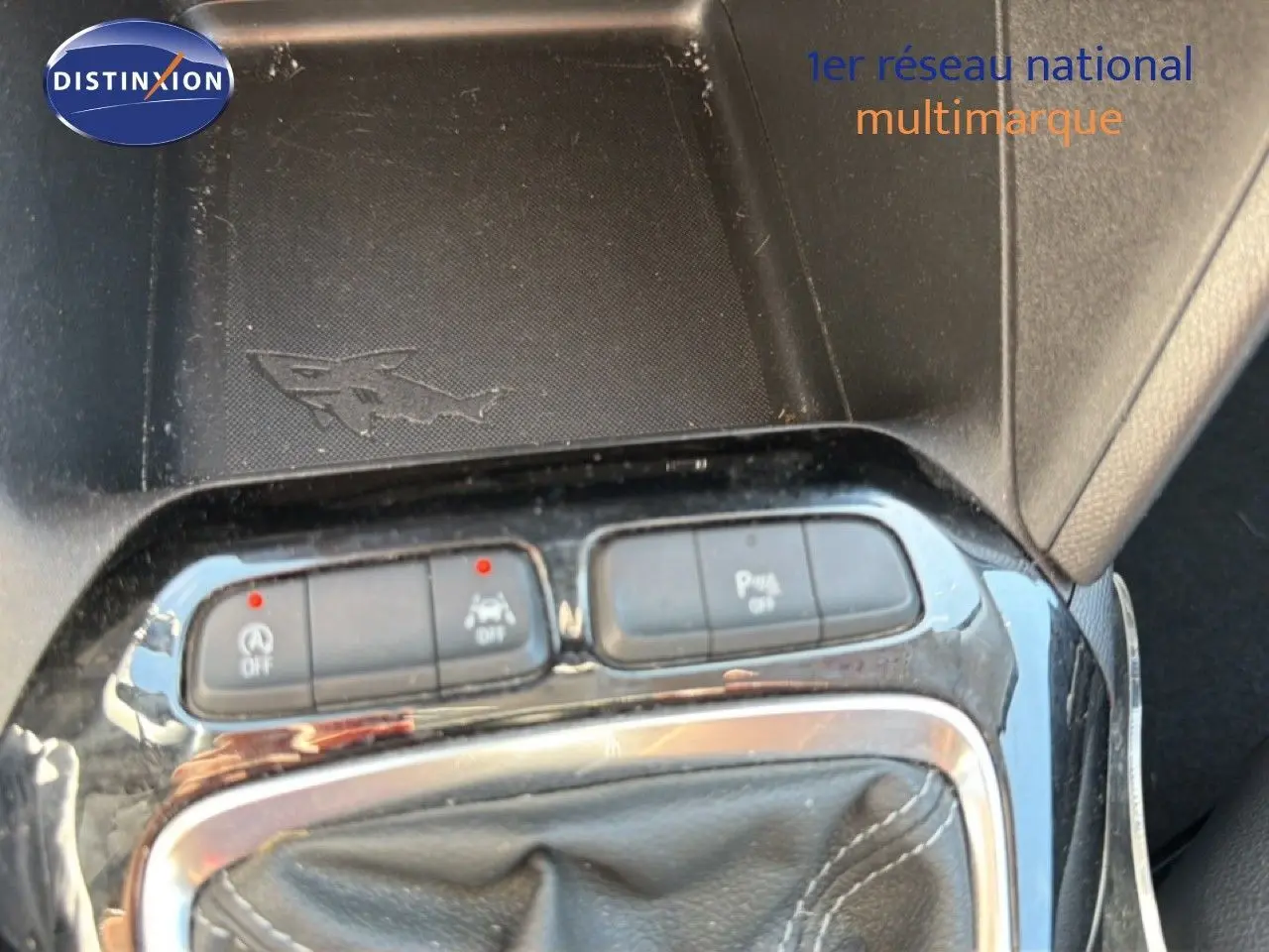 Gros plan sur la console centrale de l’Opel Corsa gris quartz, montrant les boutons de contrôle et le soufflet de levier de vitesse cuir noir.