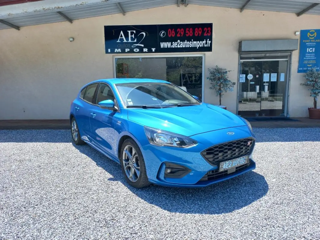 Ford Focus 2019 bleu en 3/4 avant droit, version ST-Line avec calandre noire et jantes alliage visibles.