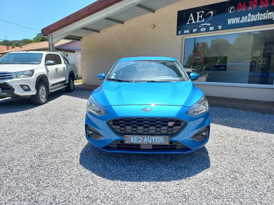 Vue de face d'une Ford Focus ST-Line bleu vif, avec calandre hexagonale et logo ST bien visible.
