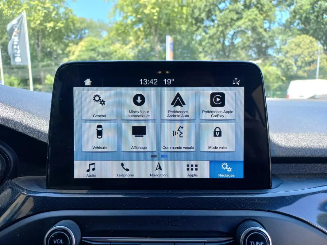 Écran tactile central de la Ford Focus 2019 bleu, vue frontale du système multimédia avec menu réglages affiché.