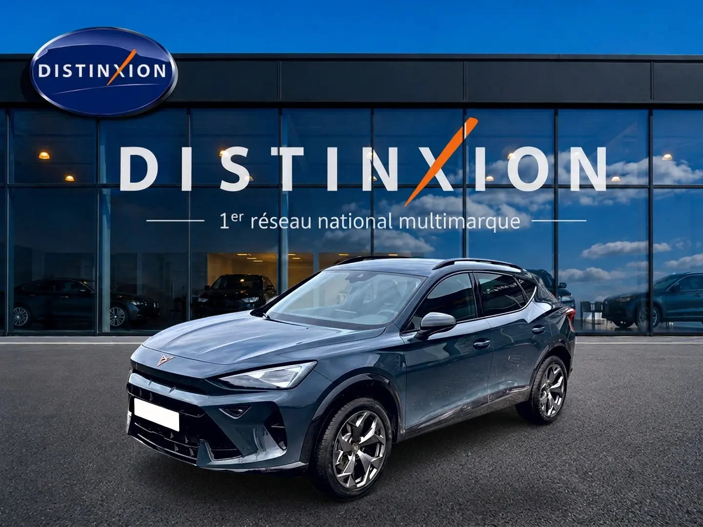 Vue 3/4 avant droit d'un CUPRA Formentor bleu fjord garé devant une concession Distinxion.