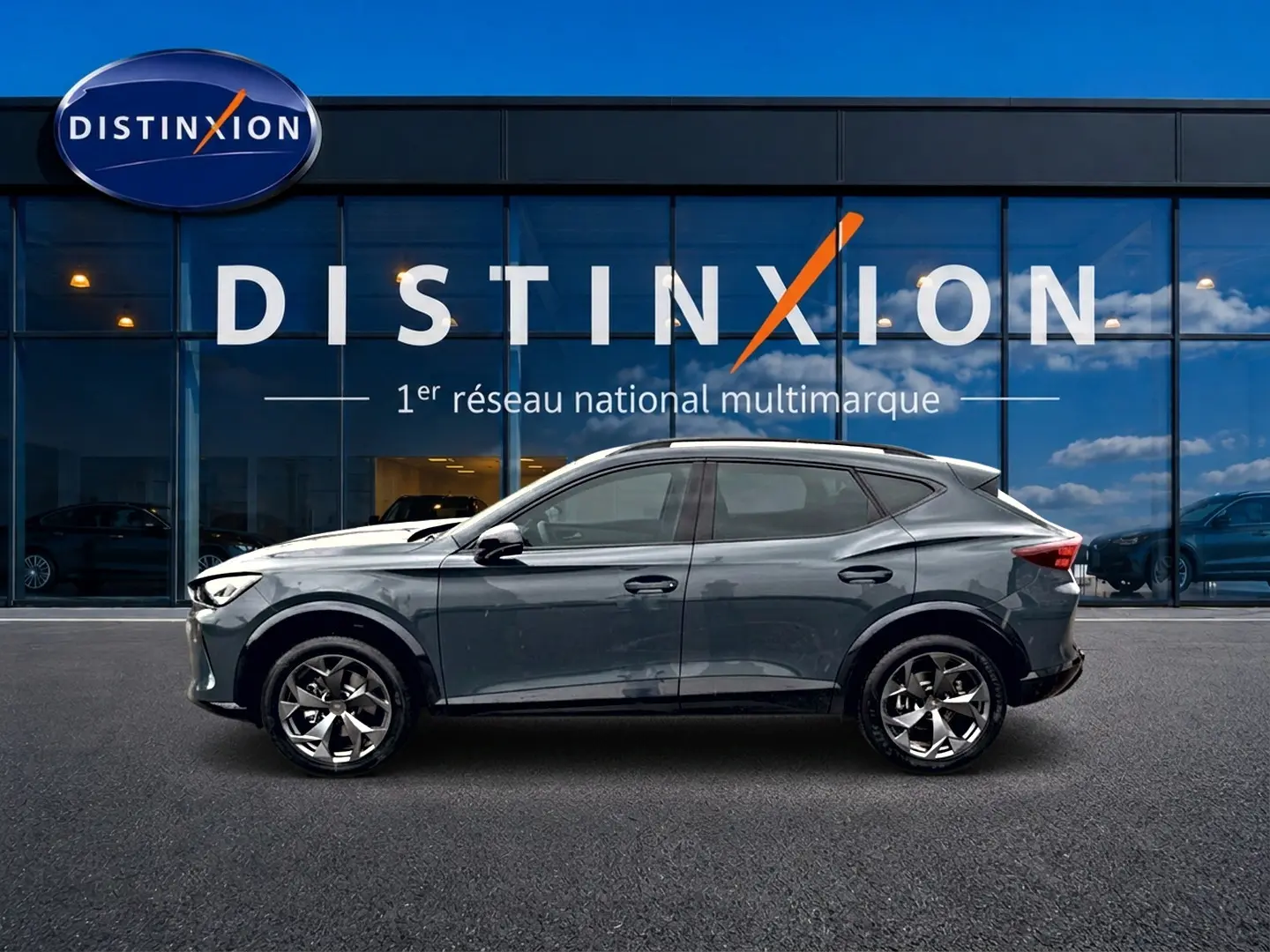 Vue latérale droite d'un CUPRA Formentor bleu fjord 2026 avec jantes 18 pouces devant une vitrine Distinxion.