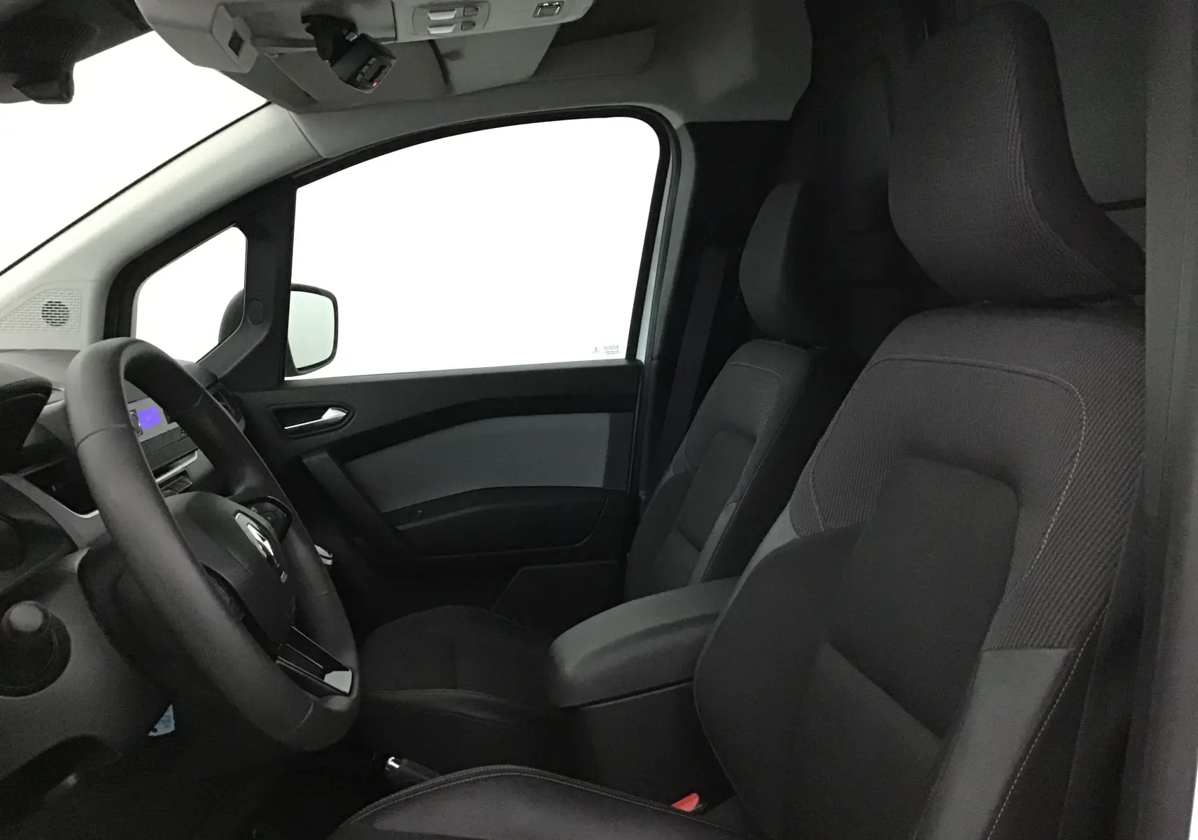 Vue intérieure côté conducteur du Renault Kangoo blanc 2022, mettant en valeur les sièges et le volant multifonction.