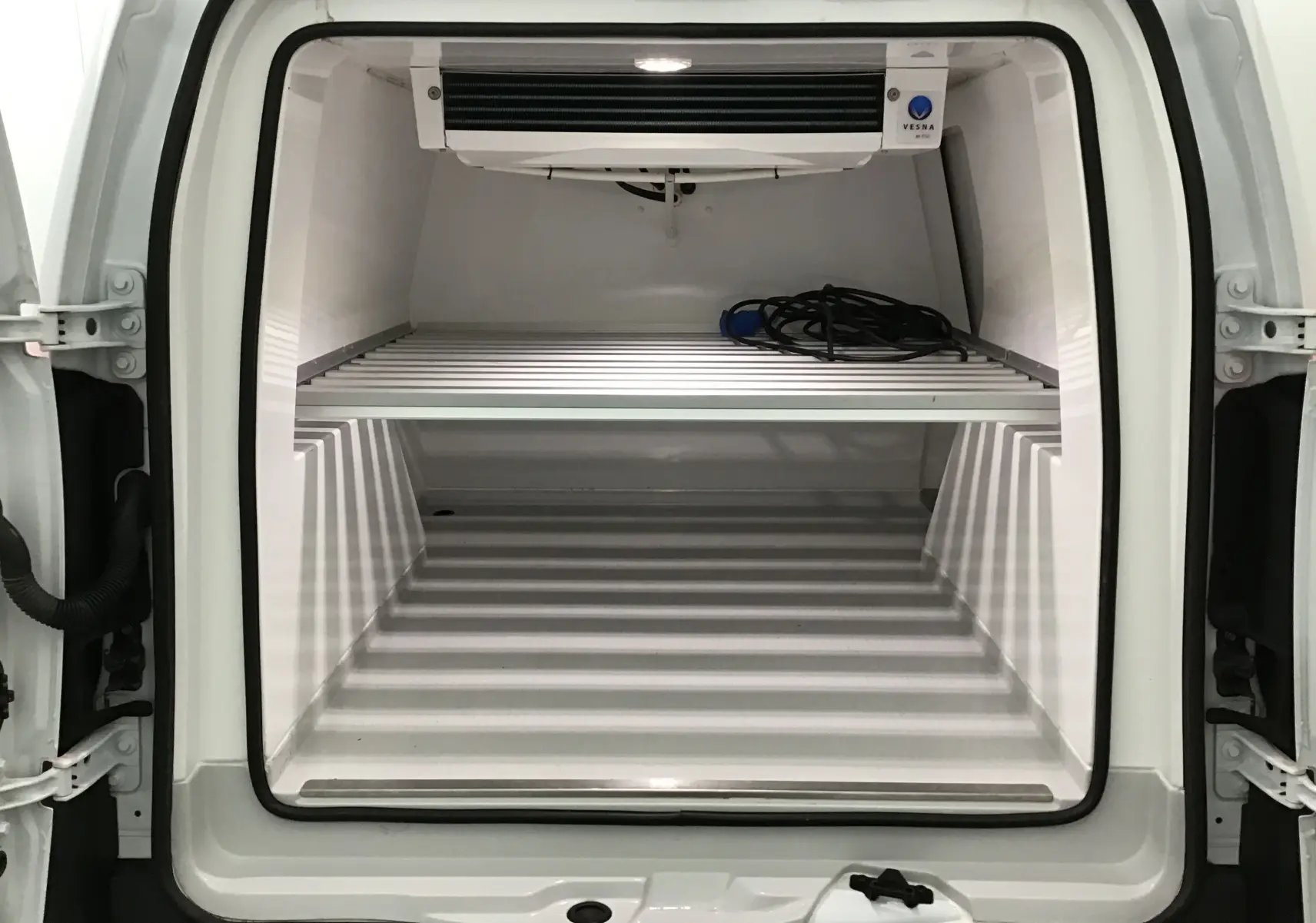 Vue arrière du Renault Kangoo blanc 2022 avec cellule frigo Vesna et étagère métallique intérieure visible.