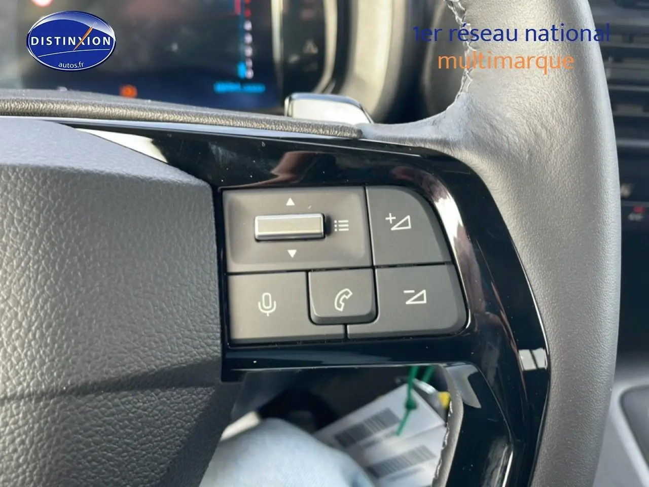 Gros plan sur les commandes audio et téléphone au volant cuir noir du Citroën Berlingo gris Artense 2025.