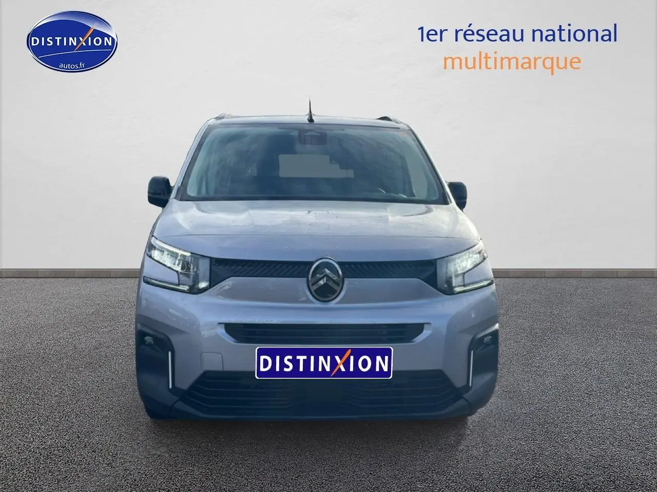 Vue avant d'un Citroën Berlingo gris artense avec calandre noire et phares LED allumés.