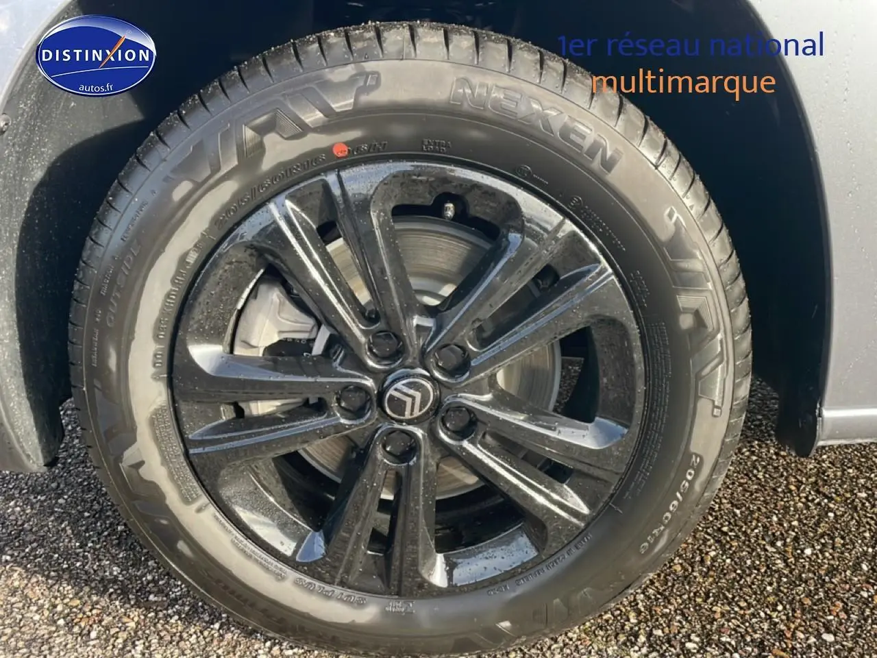 Gros plan sur la jante alu noire 16 pouces avec logo Citroën sur un Berlingo gris Artense.