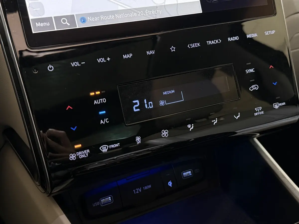 Gros plan sur la console centrale tactile noire du Hyundai Tucson 1.6 Hybrid 230 Executive avec commandes climatisation et ports USB.