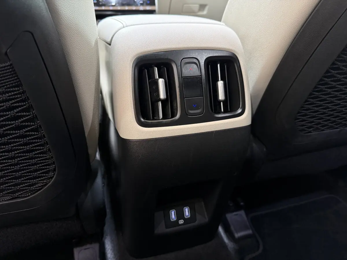 Détail des aérateurs arrière et ports USB sur la console centrale beige et noire du Hyundai Tucson 1.6 Hybrid 230 Executive.