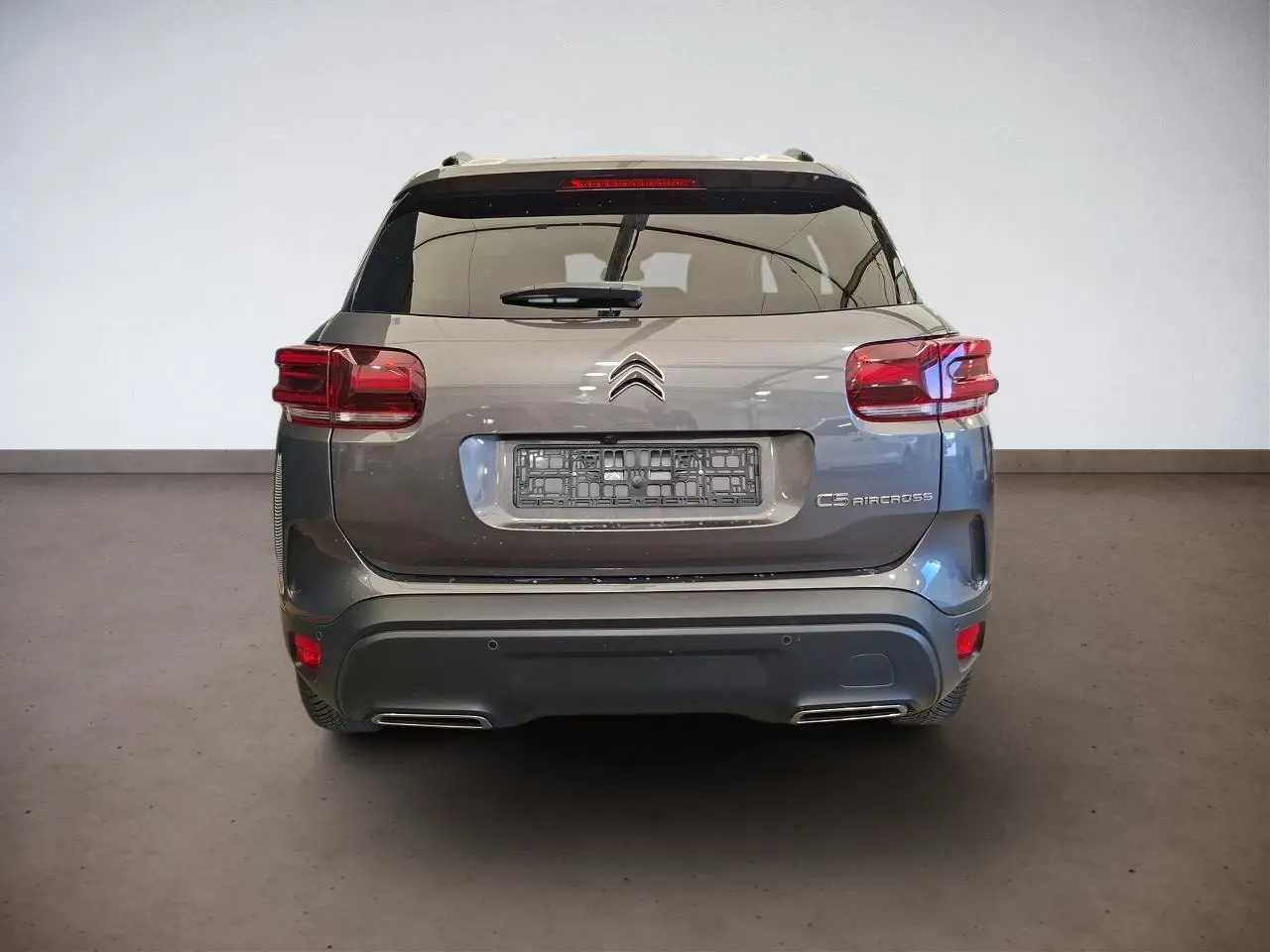 Vue arrière d'un Citroën C5 Aircross gris Platinium avec feux arrière LED et double sortie d'échappement intégrée.