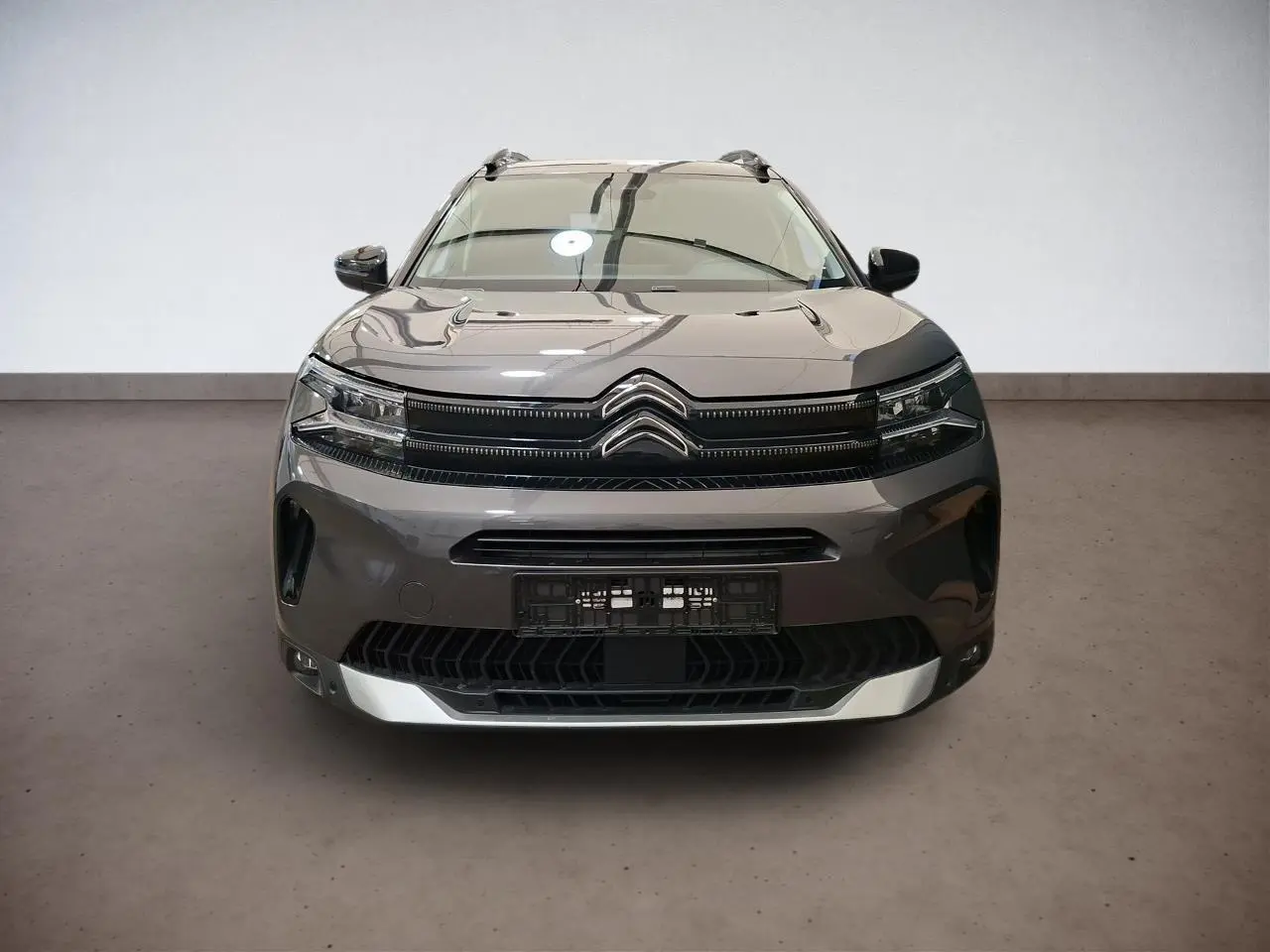 Vue frontale d'un Citroën C5 Aircross gris Platinium avec calandre noire et insert argenté sur le bouclier.