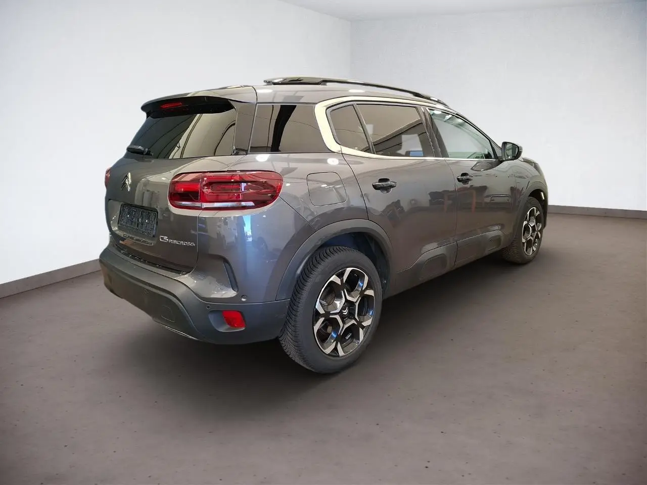 Vue 3/4 arrière droit du Citroën C5 Aircross gris Platinium avec jantes alliage bi-ton et vitres teintées.