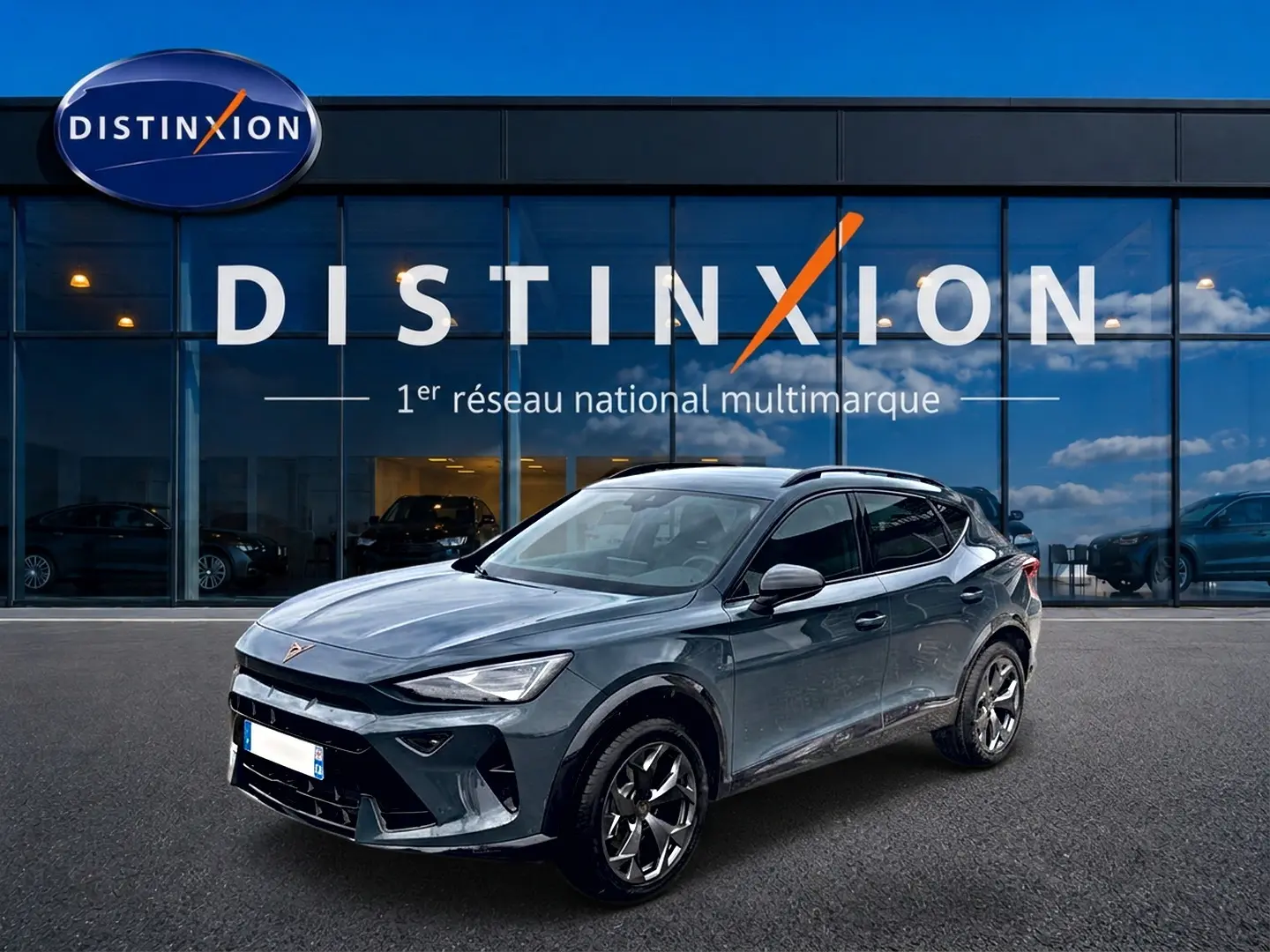 Vue 3/4 avant d'un CUPRA Formentor bleu fjord garé devant une vitrine avec logo Distinxion.