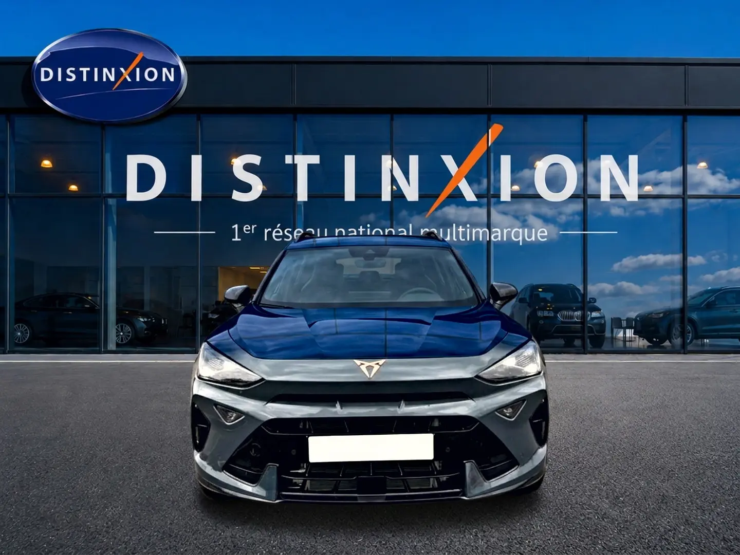 Vue frontale d'une CUPRA Formentor bleu fjord 2026 avec logo distinctif et calandre noire devant un showroom Distinxion.
