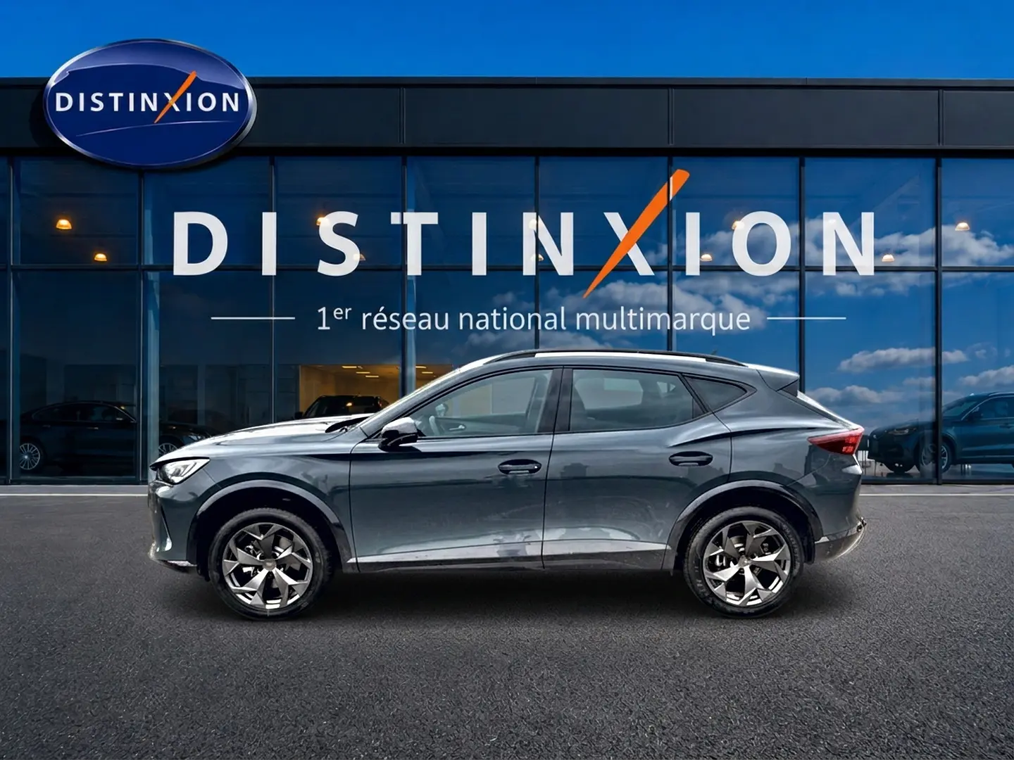 Vue latérale droite d'un CUPRA Formentor 2026 gris métallisé devant une vitrine Distinxion.