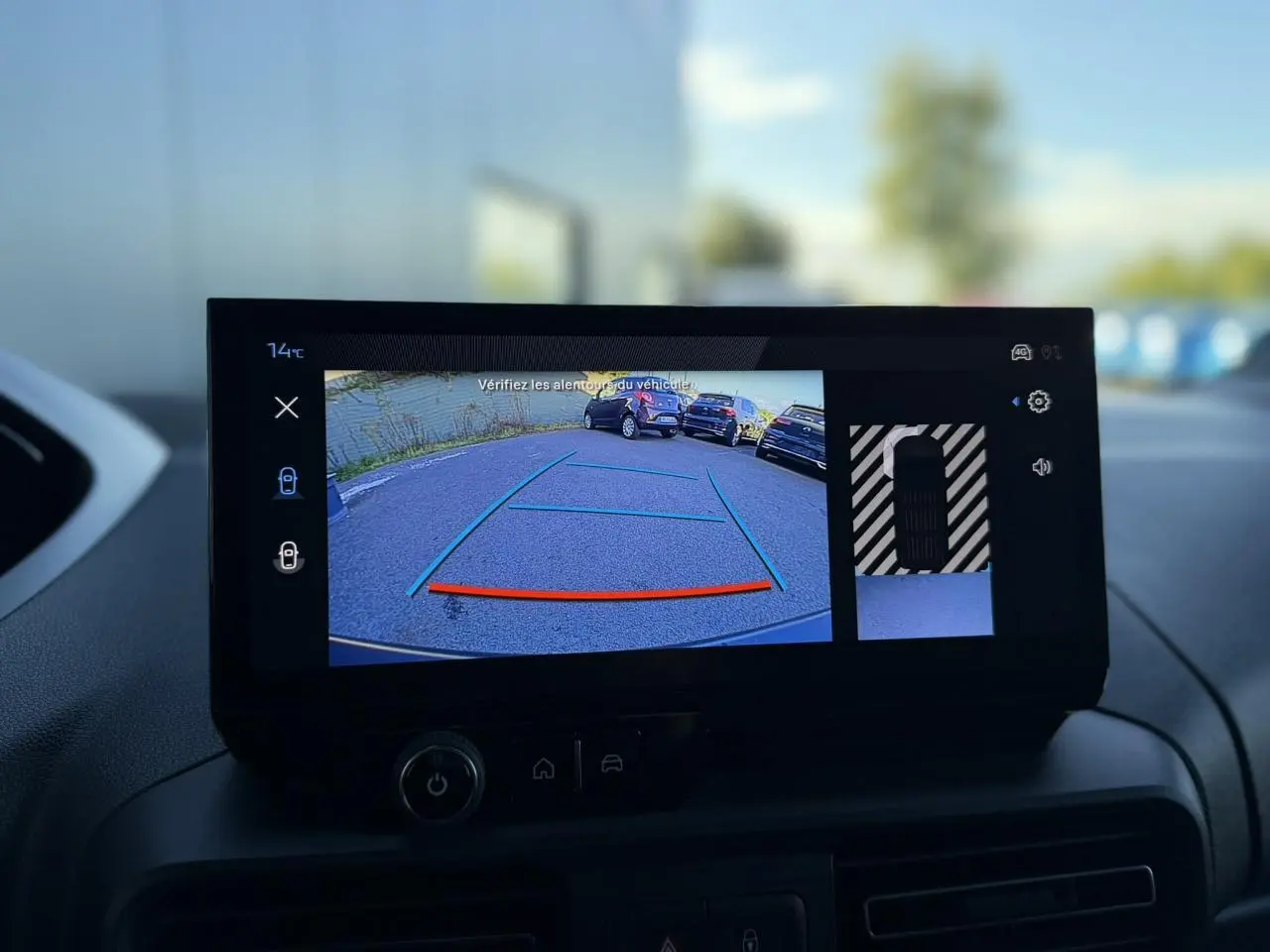 Écran tactile intérieur du Peugeot Partner 2026 montrant la caméra de recul avec guidage et vue 360° du véhicule blanc.